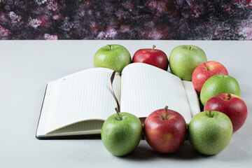 Red and green apples with a blank recipe book aside