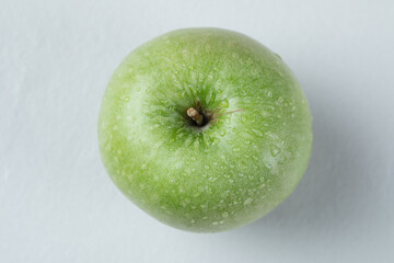 A single green apple isolated on the grey background
