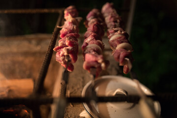 Meat with smoke on the barbecue grill. Fried meat of pork,beef, lamb on skewers are fried on fire, skewers on a metal skewer are grilled in the open air. Picnic concept