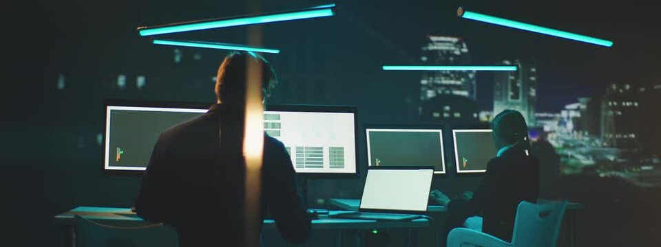Professional Financial Data Analysts Working in a Modern Monitoring Office with Live Analytics Feed on a Digital Screens.