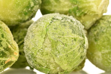 Several frozen Brussels sprouts, close-up, isolated on white.
