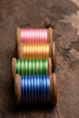 spools of thread on a wooden background