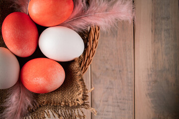 White and orange easter eggs on a light wooden background.