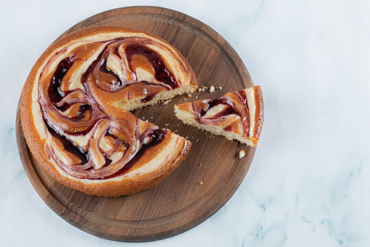 Cutting a slice of strawberry cake on a wooden baord