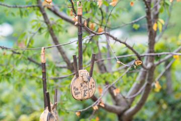  Two old and traditional handmade guitars Hanging in the trees in a summer day. High quality photo