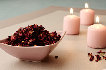 Dried rose petals in pink bowl with pink candles.