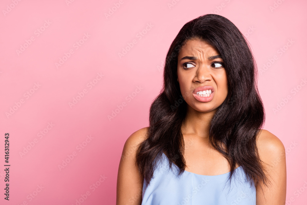 Poster portrait of sad brunette lady look empty space wear blue top isolated on pastel pink color backgroun