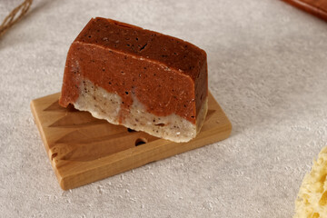 Red natural soap bar on wooden soap holder. Organic cosmetic.