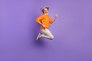 Full size photo of young happy excited funky old man jumping playing invisible guitar isolated on purple color background