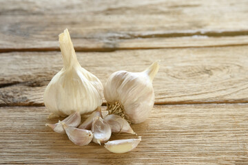 Pile of white garlic on wooden floor.