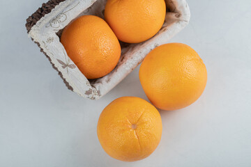 A wooden basket full of fresh orange fruits