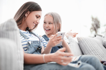 close up.happy mom and her daughter are watching videos on smartphone
