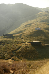 Sunset Peak grassland view with abandoned stone house in winter under the sun light in Hong Kong Lantau Island