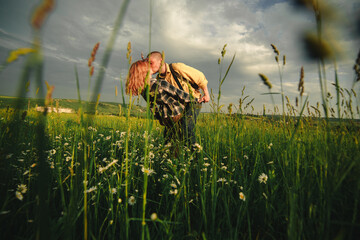 Loving hipster couple walking in the field, kissing and holding hands, hugging, lying in the grass in the summer at sunset. valentines day