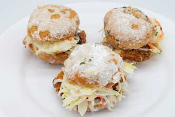 Three Delicious Chicken Beignet Sliders with Coleslaw on a White Plate