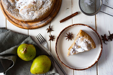 A delicious slice of pear pie on a white plate. Top view. Pear pie on a white table