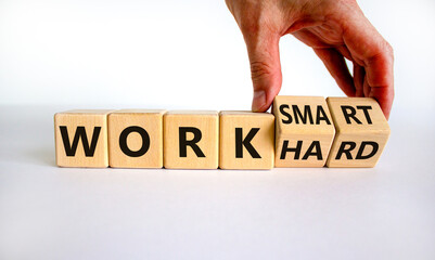 Work hard or smart symbol. Businessman turns wooden cubes and changes words 'work hard' to 'work smart'. Beautiful white background, copy space. Business and work hard or smart concept.