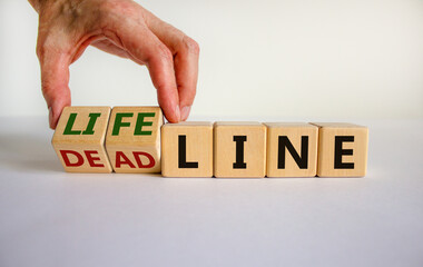 Lifeline or deadline symbol. Businessman turns wooden cubes and changes the word 'deadline' to...