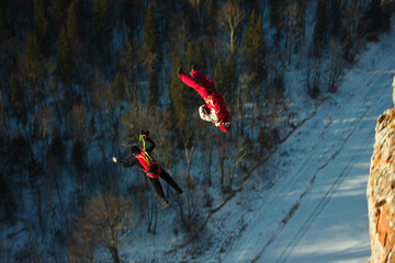 Two basejumpers athletes are in free fall after jumping from a high cliff, a second before opening...