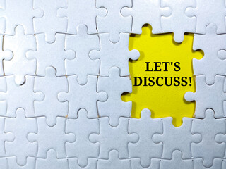 Selective focus.Word LET'S DISCUSS with jigsaw puzzle on yellow background.Business concept.