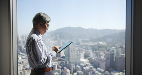 Fototapeta premium man use tablet near window