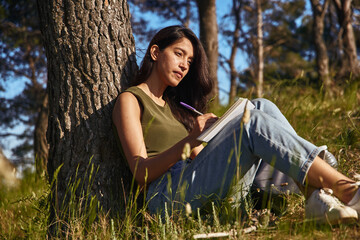A reflective young lady pausing her writing