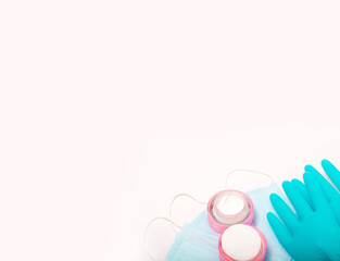 Beauty accessories on white background. Blue gloves, masks, and cream.