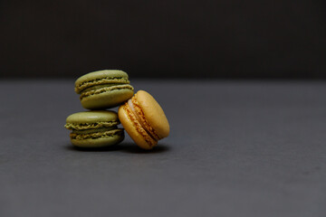 Yellow and greens french macarons on grey background