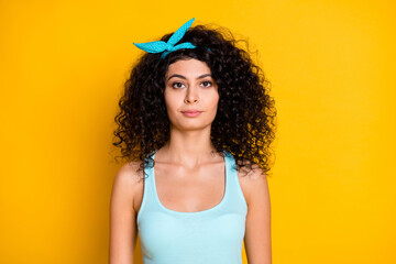 Photo of serious confident wavy lady dressed turquoise tank-top isolated yellow color background