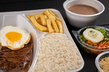 Steak lunch with egg, rice, beans, farofa, and salad