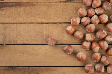 A group of hazelnuts over rustic wooden table with copy space