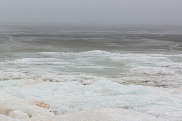 Sea view with frozen water, ice cubes and snow in foreground at the Baltic sea in February in Latvia