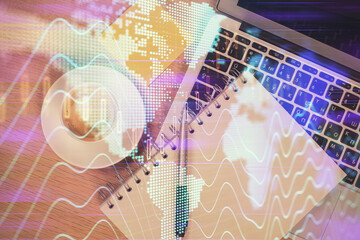 Double exposure of forex chart drawing over table background with computer. Concept of financial...