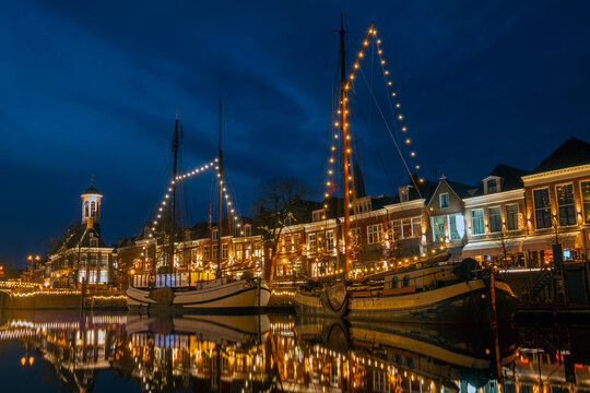 Traditional boats in the harbor from Dokkum in the Netherlands in christmas time at twilight