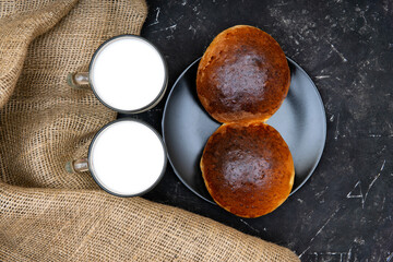 Rural breakfast: homemade buns and milk on burlap cloth