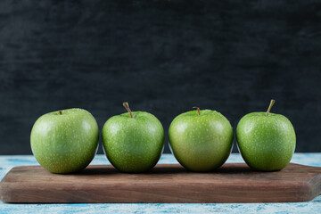 Juicy apples in a row on a wooden board