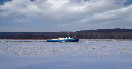 Icebreaker in operation breaking ice floes on the river