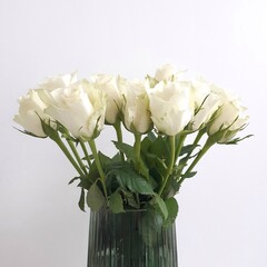 White roses in green glass vase
