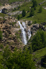 Naklejka na ściany i meble mountain stream with small waterfall in wide alpine field