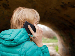 BLOND WOMAN TALKING ON THE PHONE IN A TUNNEL