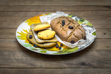 Homemade fresh bread, tortillas and cookies on round dish on wooden table