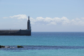 Fototapeta premium Statue at the end of the pier at the entrance to the harbor of Tarifa.