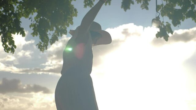 young woman walking on a tree, finding balance, backlit sunglare 4 K