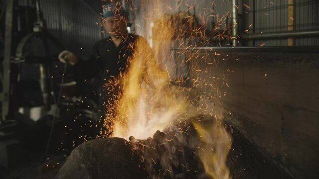 Japanese swordsmith make a fire from charcoal.
