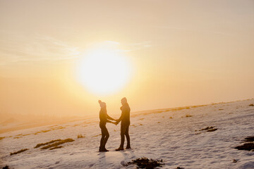 Liebespaar bei Sonnenuntergang im Schnee
