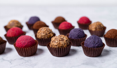 colored homemade energy balls - truffles made of cocoa, blueberry and beetroot powder