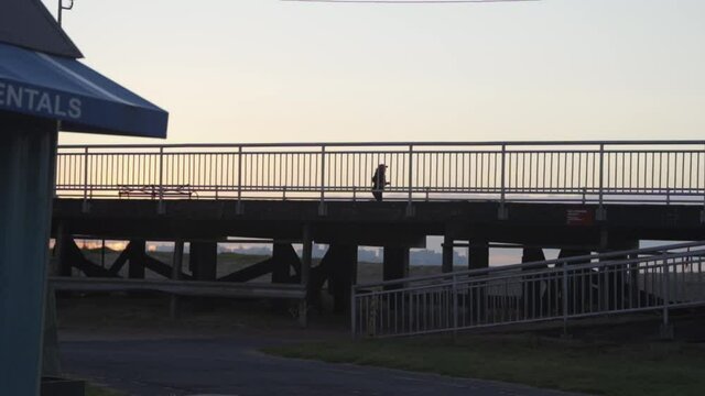 Silhouette Of A Woman Running At Early Morning On Pier. Staten Island, New York City USA. Slow Motion