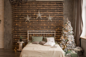 Bed with New Year's decorations. New Year's interior. Christmas tree.