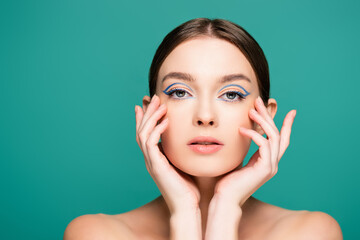 young woman with creative makeup posing with hands near face isolated on green
