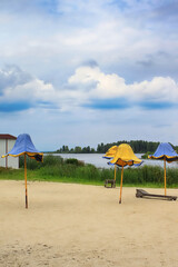Beautiful beach with tents in the form of tulips in colors of national flag (blue and yellow) and the Dnieper River in town of Ukrainka, Kyiv region, Ukraine